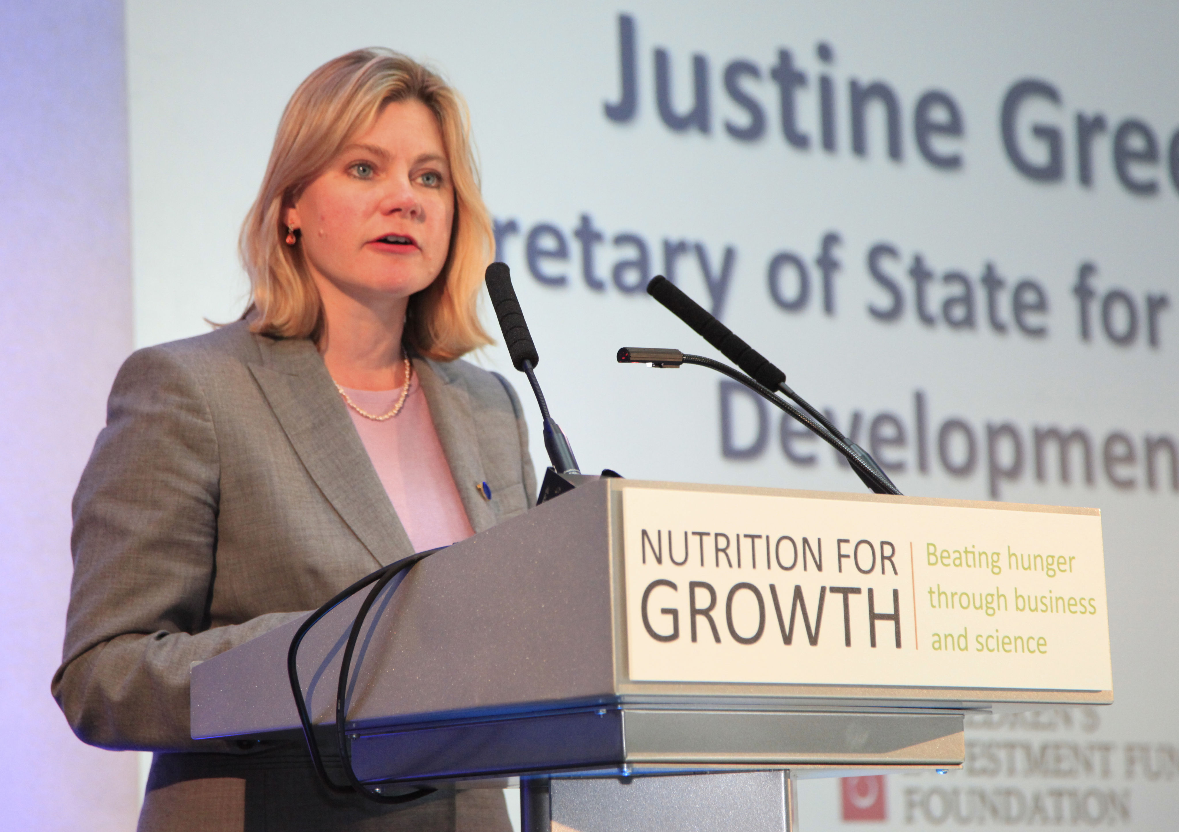Justine Greening, Secretary of State for International Development, at a podium labelled "Nutrition for Growth"