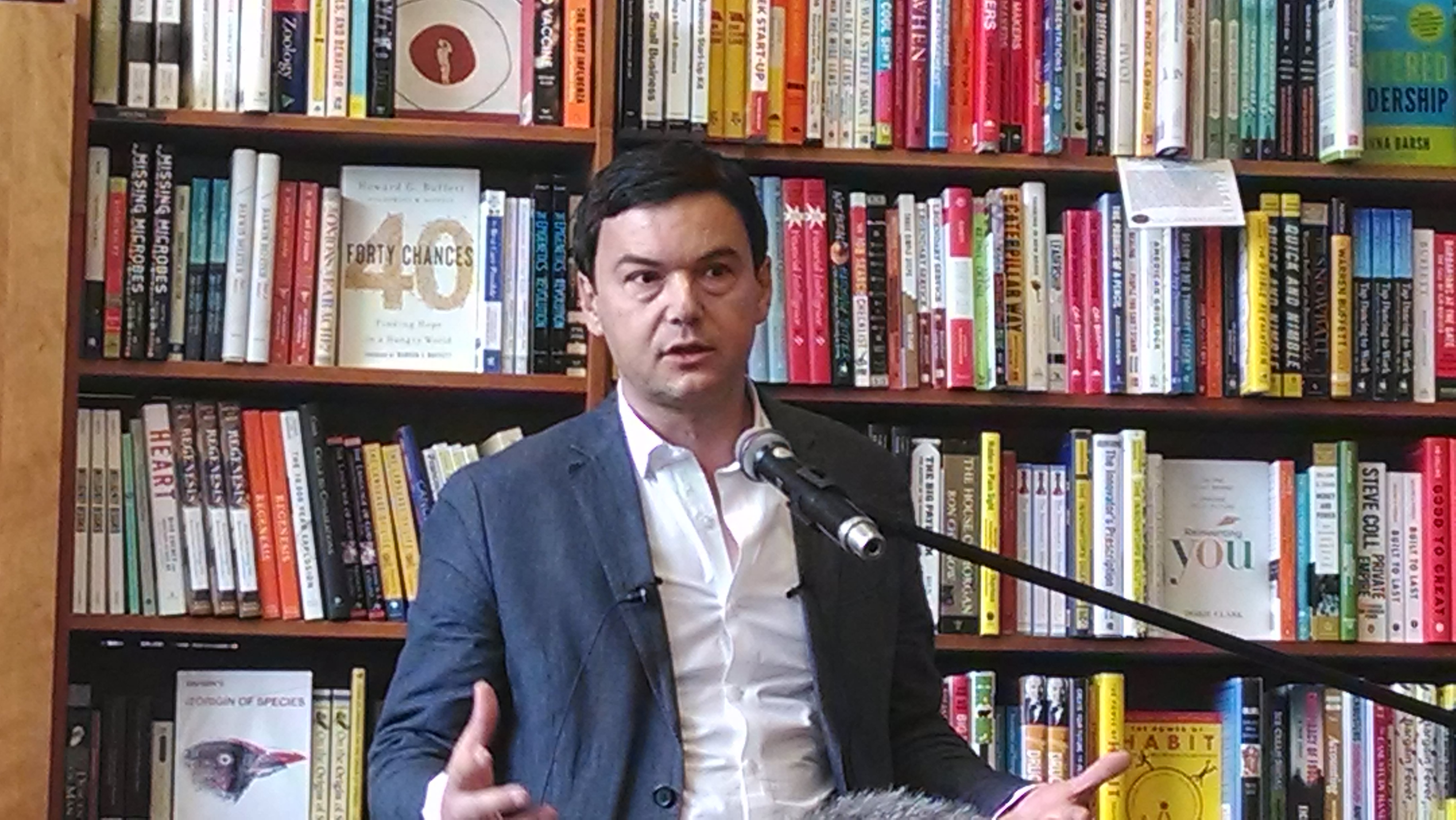 A picture of Thomas Piketty in front of a bookcase